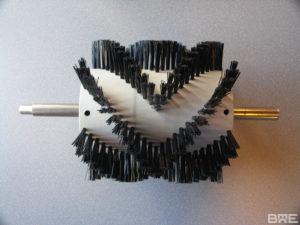 Brosse rotative avec axe et garnissage chevron