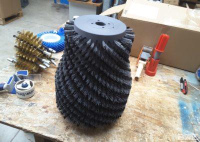 Brosse rotative cylindrique garnie de filaments pour le nettoyage des bouteilles de vin.