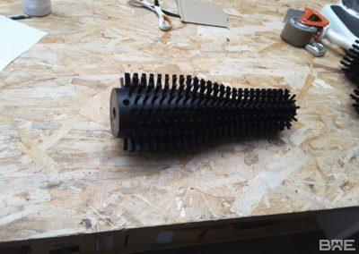 Brosse rotative cylindrique avec garnissage de forme spécifique conçue pour le nettoyage des bouteilles dans le secteur viticole.