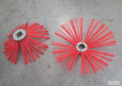 Brosse de désherbage mécanique utilisée pour le nettoyage des pieds de vigne dans le secteur viticole. L'outil est fixé à un tracteur et comporte des brosses rotatives qui permettent d'éliminer les herbes au pied des ceps sans les abîmer.