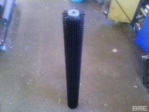 Une brosse rotative longue fixée sur une machine de nettoyage industrielle est présentée. Sa structure cylindrique et ses poils denses en font un outil idéal pour éliminer la terre et les impuretés des pommes de terre en mouvement.
