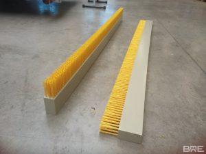 Une brosse plate de grande longueur, fixée sur un racleur à lisier, permettant le nettoyage efficace des sols des étables.