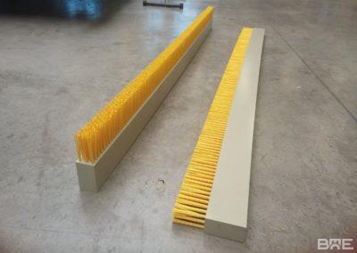 Une brosse plate de grande longueur, fixée sur un racleur à lisier, permettant le nettoyage efficace des sols des étables.