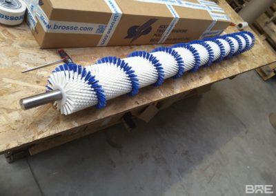 Brosse rotative cylindrique avec garnissage en hélice pour le convoyage et le brossage des graines de haricot.