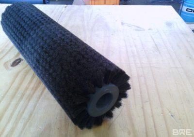 Brosse cylindrique à garnissage dense et souple utilisée pour le lustrage des pommes sur une ligne de conditionnement en agriculture. La brosse est constituée d'un corps cylindrique garni de filaments en fibres synthétiques, permettant un polissage doux et efficace des fruits.