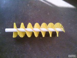 Une brosse technique industrielle conçue pour le transport efficace des résidus de raisin sur les convoyeurs dans le secteur viticole.