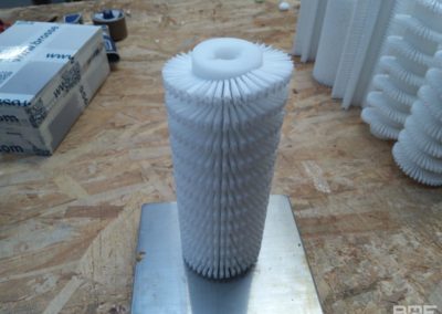 Brosse cylindrique avec garnissage dense en hélice, conçue pour une utilisation dans les machines blistéreuses pharmaceutiques.