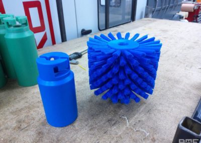 Une machine à frotter les fromages utilise une brosse cylindrique modulaire pour brosser une meule de Comté.