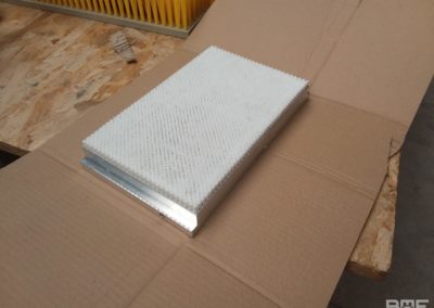 Une brosse plate avec des poils en polypropylène, fixés sur un support en aluminium, conçue pour le convoyage de produits dans l'industrie pharmaceutique.