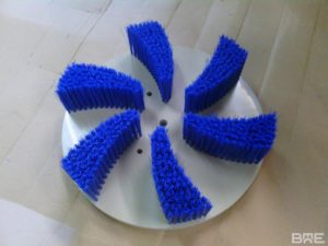 Brosse plateau sur mesure utilisée pour le brossage des meules de fromage dans l'industrie fromagère.