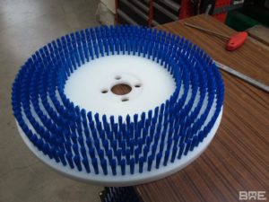 Brosse plateau modulaire utilisée pour le brossage des meules de fromage dans l'industrie fromagère.