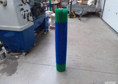 Une brosse rotative avec un garnissage en trois sections, conçue pour une utilisation sur un robot de nettoyage des panneaux solaires. La brosse est fixée à un support métallique et présente des poils souples et denses pour un nettoyage efficace des surfaces délicates.