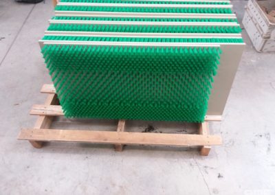 La brosse est constituée de plaques en plastique garnies de fibres synthétiques souples. Les plaques sont fixées à la rampe et s'adaptent à sa forme, offrant une surface rugueuse et sûre pour les anguilles.