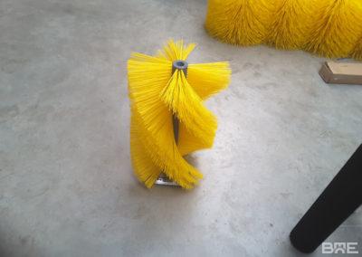 Une brosse cylindrique en hélice avec des poils souples est présentée, conçue pour le nettoyage efficace des bandes transporteuses.