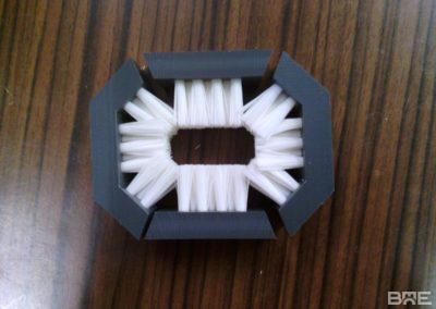 Une brosse à torsion industrielle est utilisée pour l'emballage de bonbons. Elle est composée de filaments rigides en nylon montés sur un mandrin métallique. La brosse tourne à grande vitesse, ce qui crée une friction qui tord l'emballage en papier autour du bonbon.