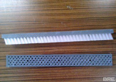 Une brosse technique industrielle avec un garnissage dense incliné, conçue pour guider les produits dans une machine d'emballage.