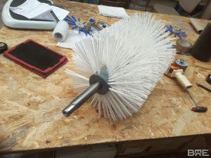 Brosse cylindrique en hélice à poils rigides pour le nettoyage des bandes transporteuses