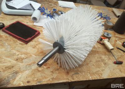Brosse cylindrique en hélice à poils rigides pour le nettoyage des bandes transporteuses